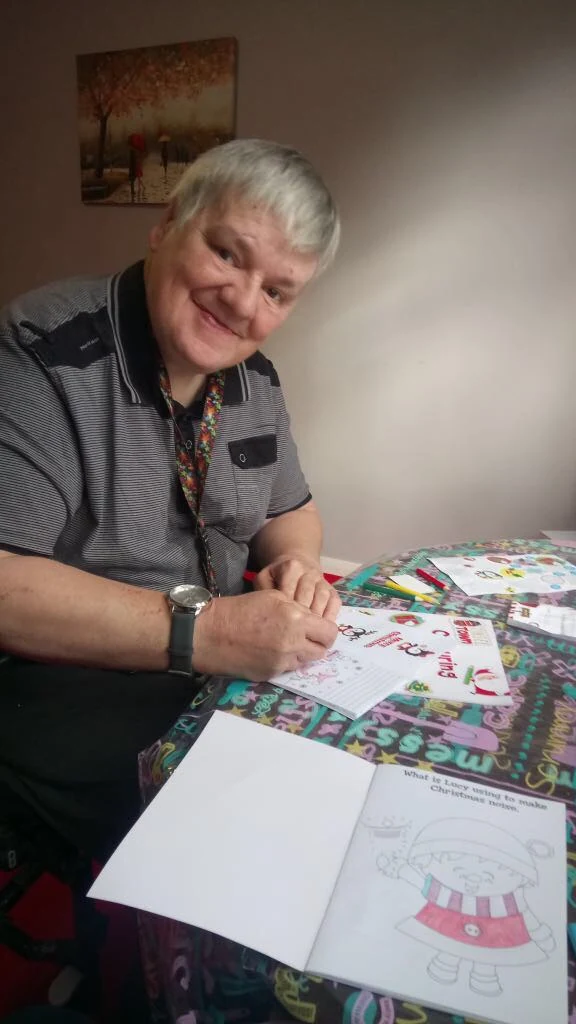 A woman working on a colouring activity