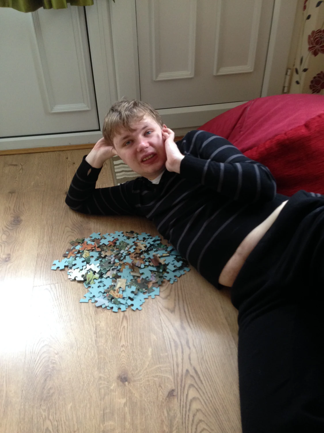 A man relaxing beside a jigsaw puzzle
