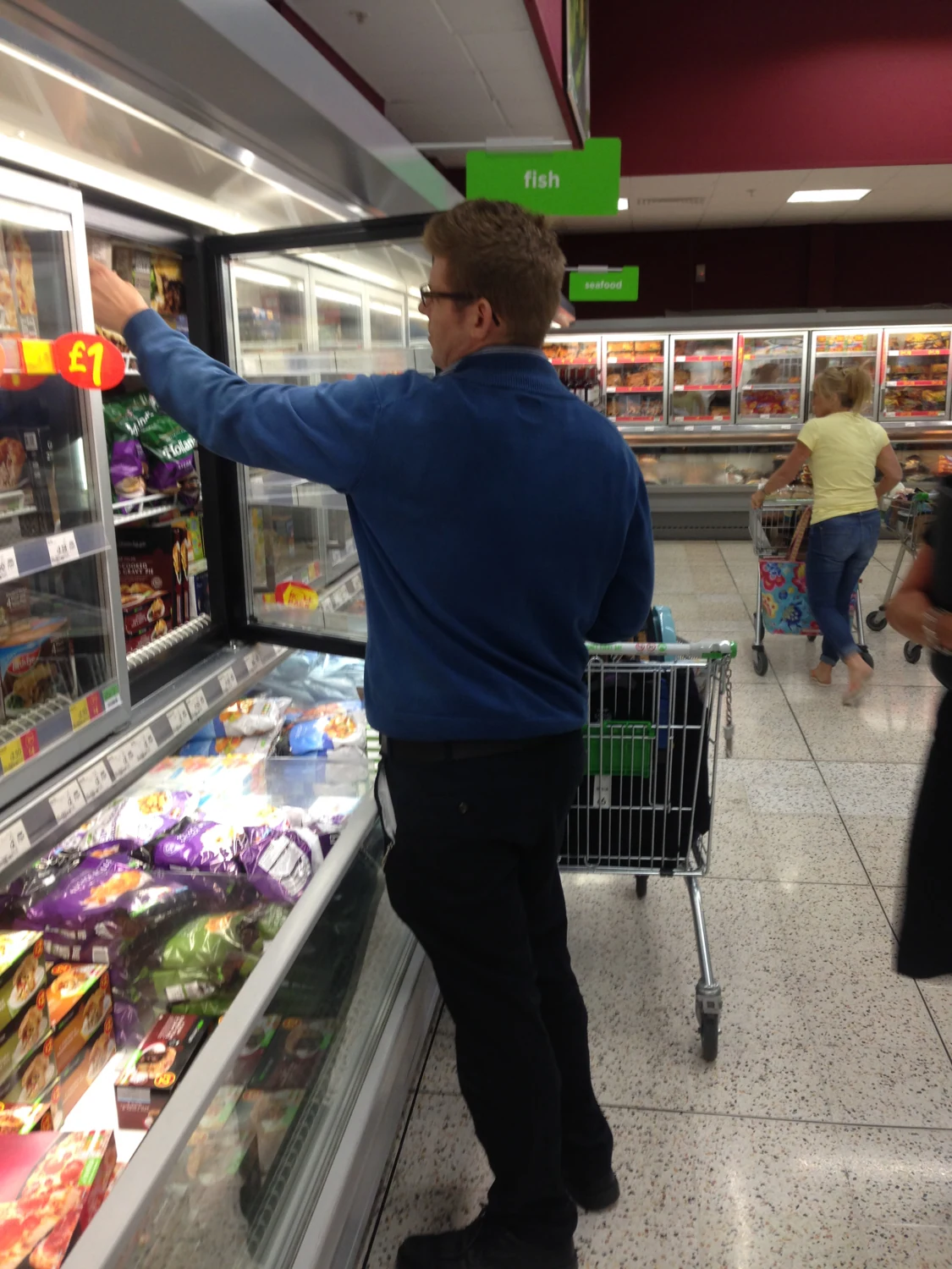 A man browsing a supermarket aisle
