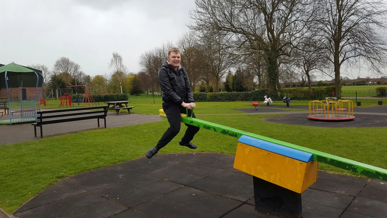 A man playing on a seesaw outdoors