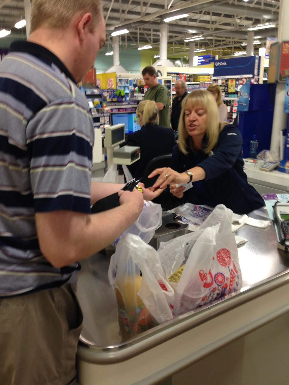 A shopper paying at a supermarket checkout