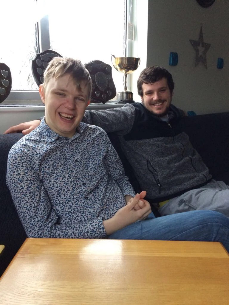 Two men relaxing together on a sofa