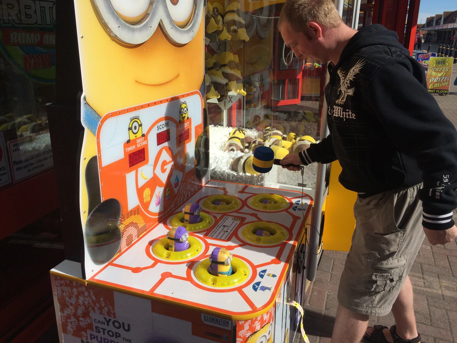 A man playing an arcade game with large colourful buttons
