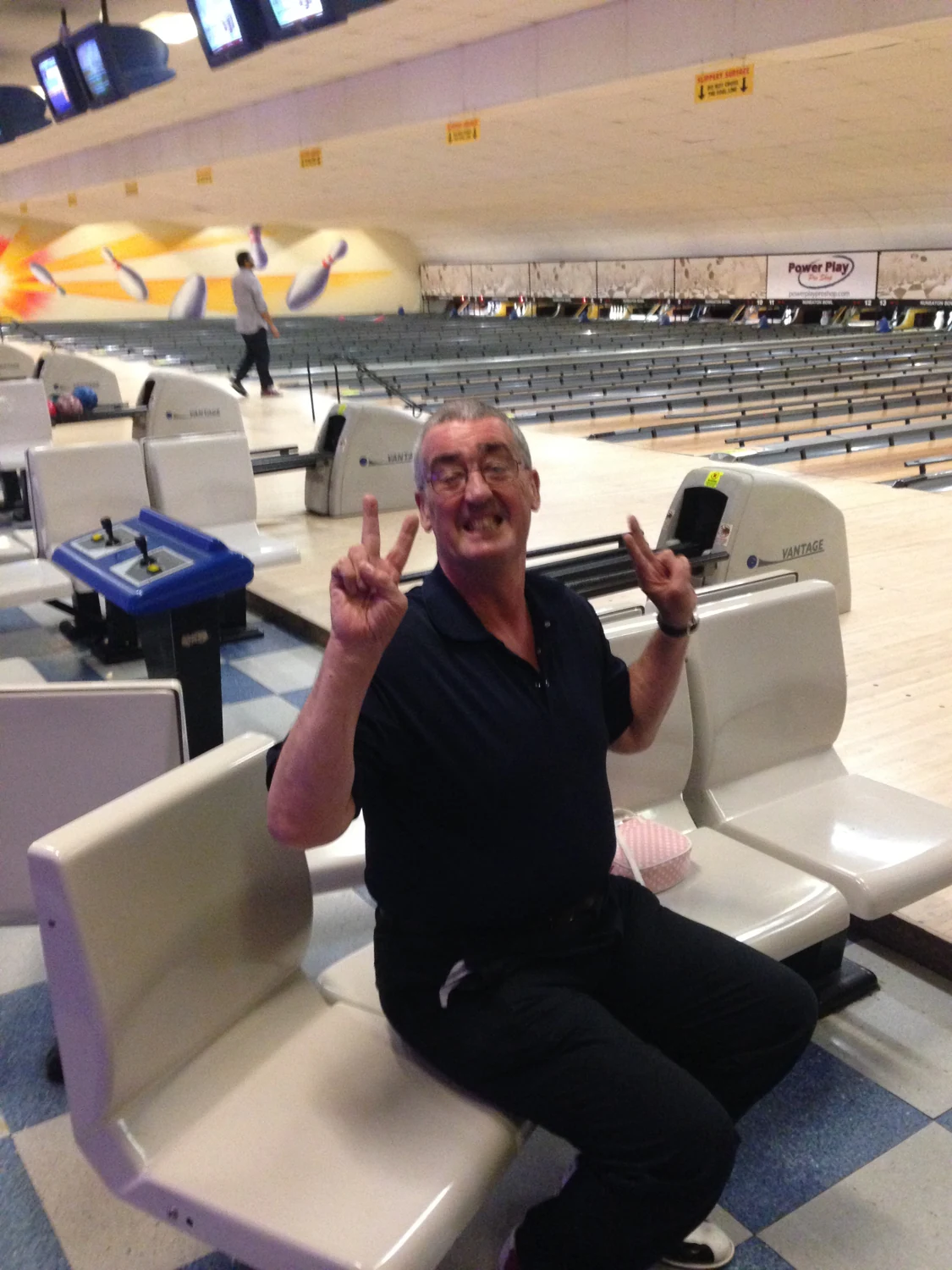 A man smiling at a bowling alley