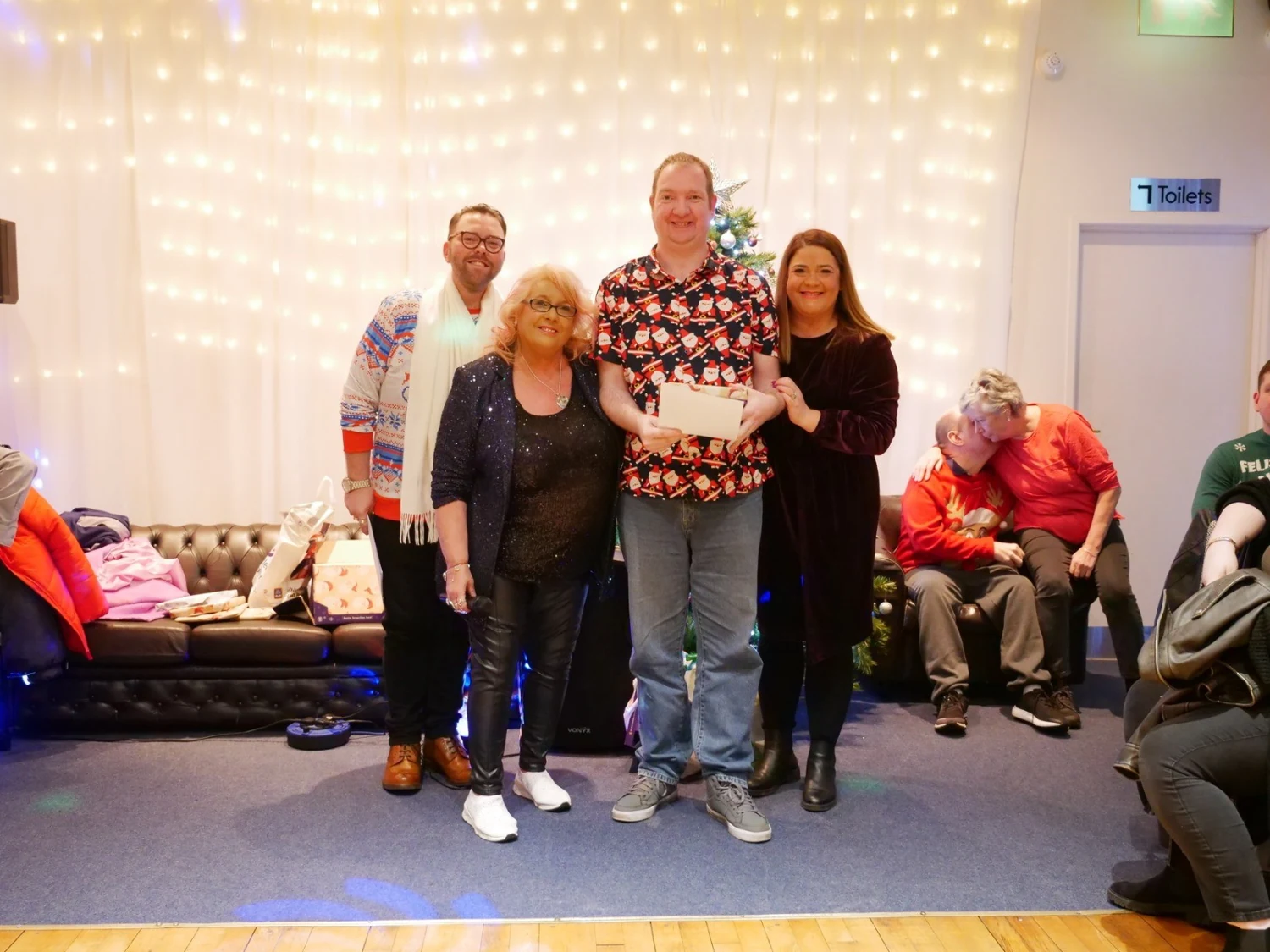An awards recipient in a patterned top with two supporters