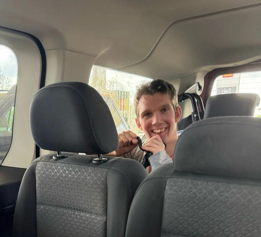 A smiling man travelling in a car