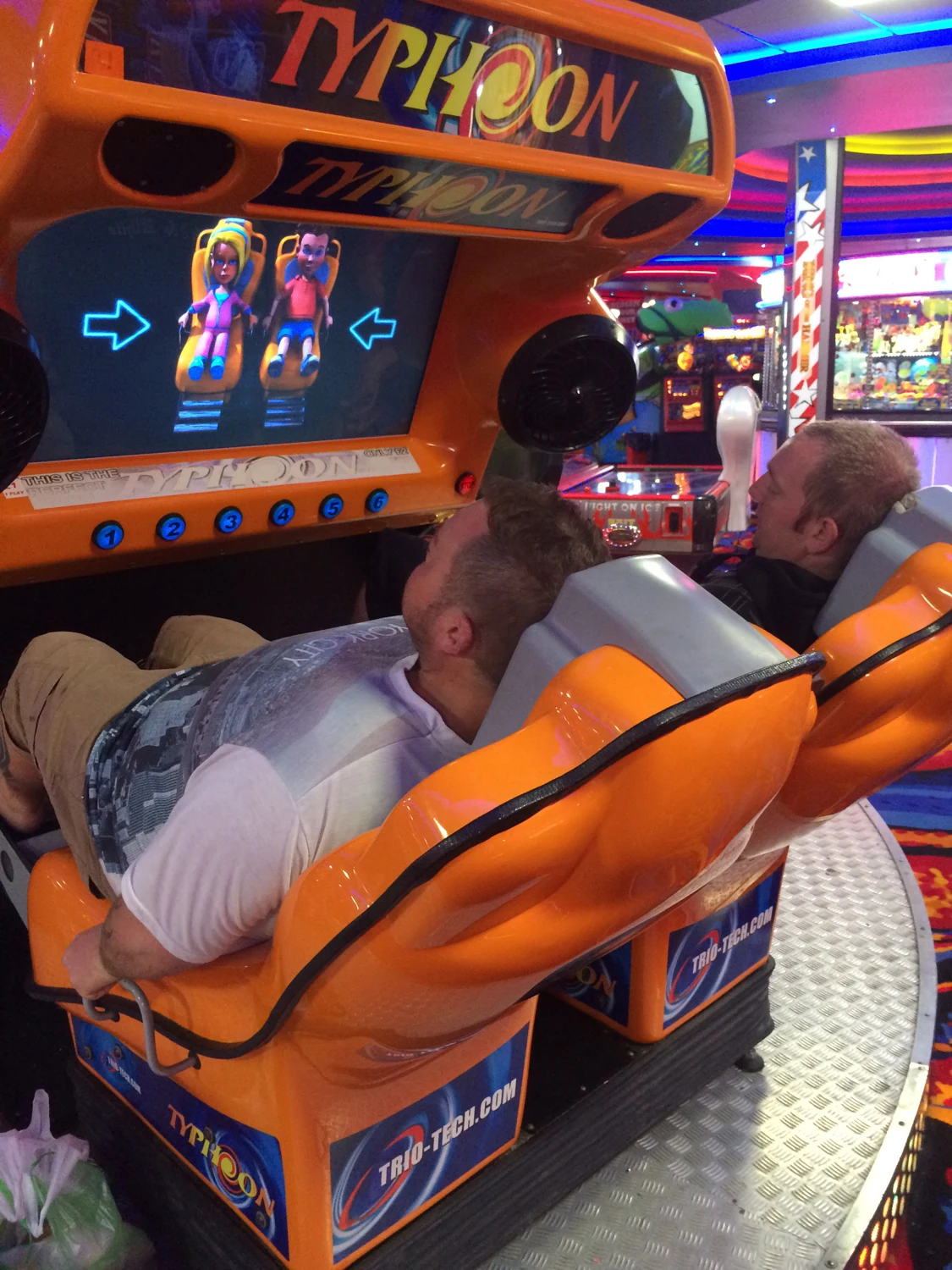 A person seated on a ride inside an arcade