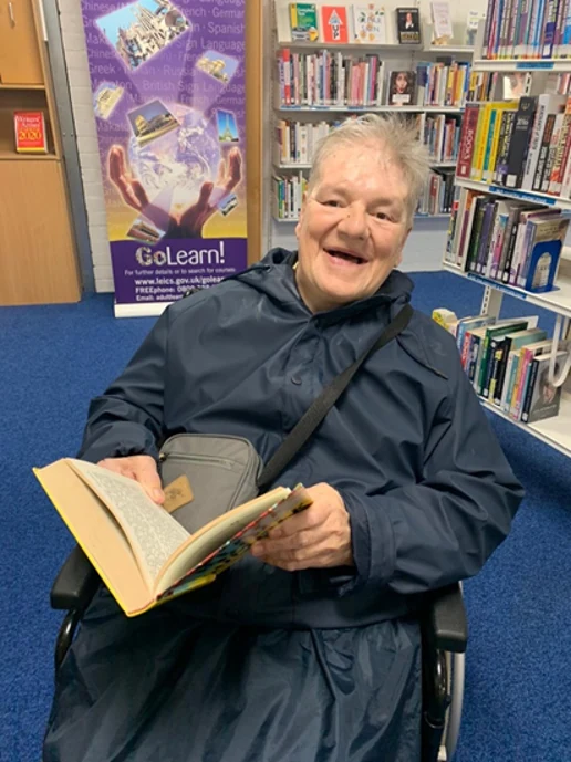 A man smiling with an open book