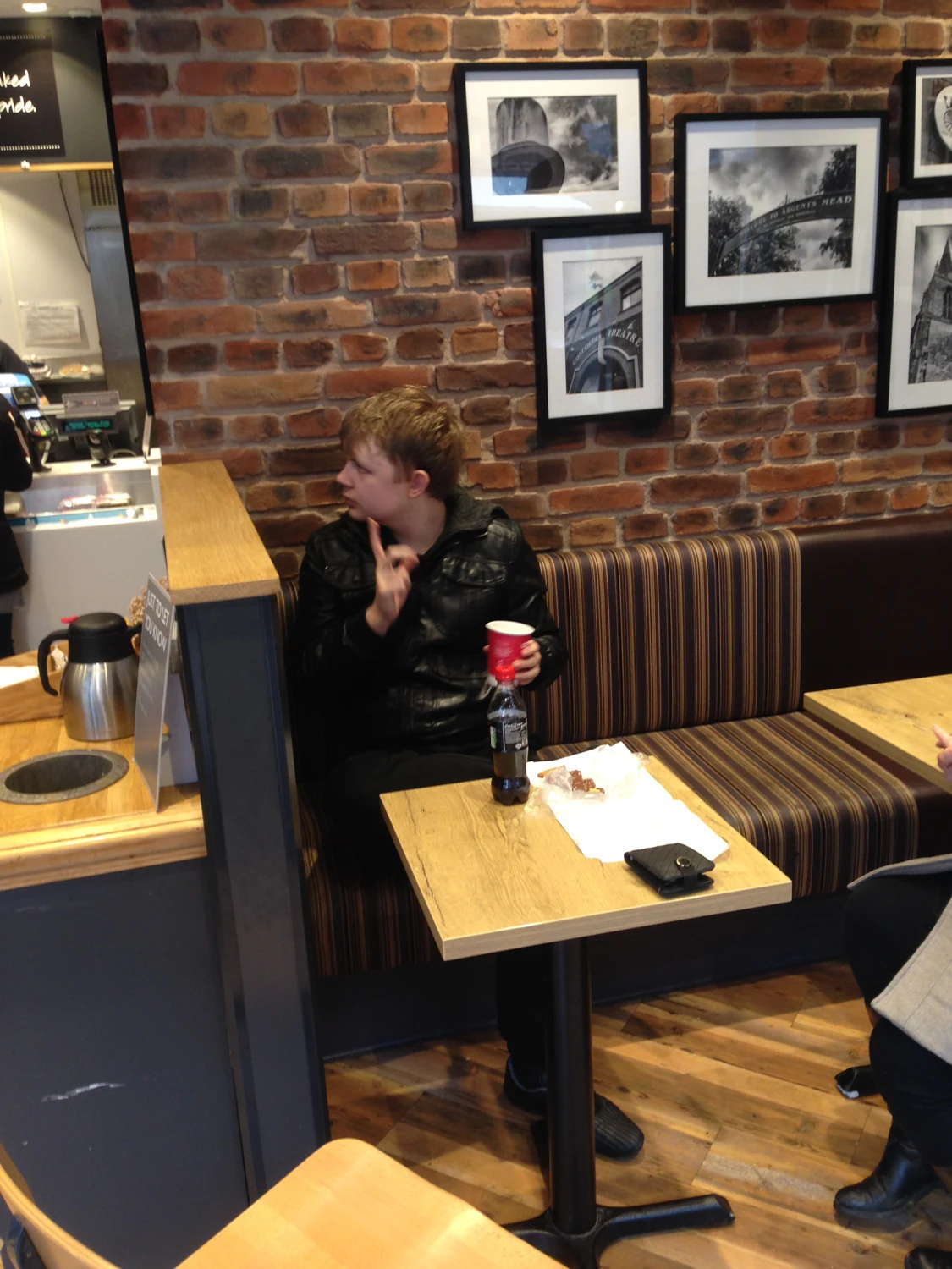 A man enjoying a drink at a cafe table
