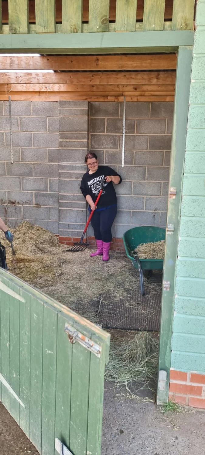 A person working inside a stable