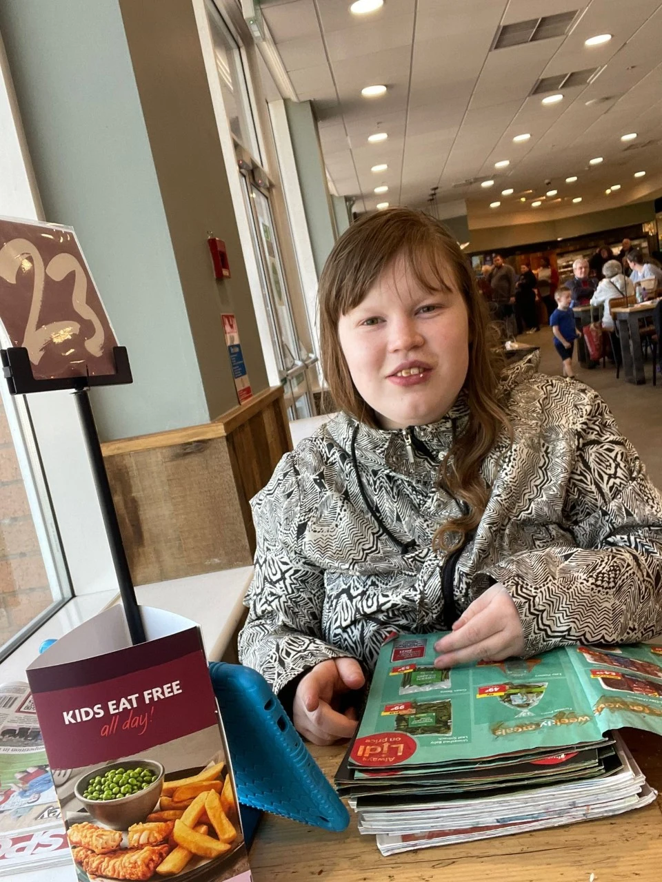 A woman sitting with a menu in a cafe