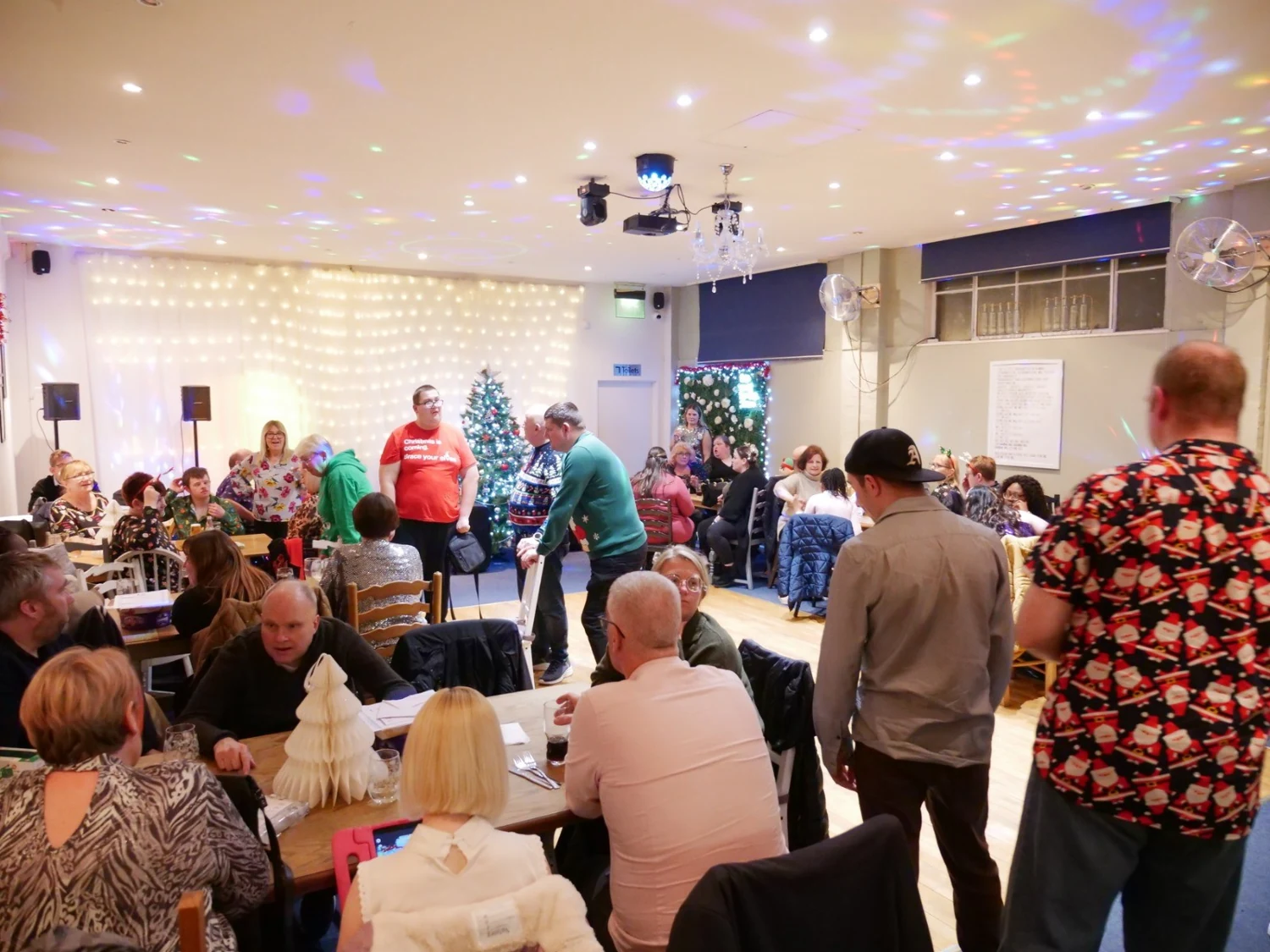 People gathered in a decorated hall for a celebration