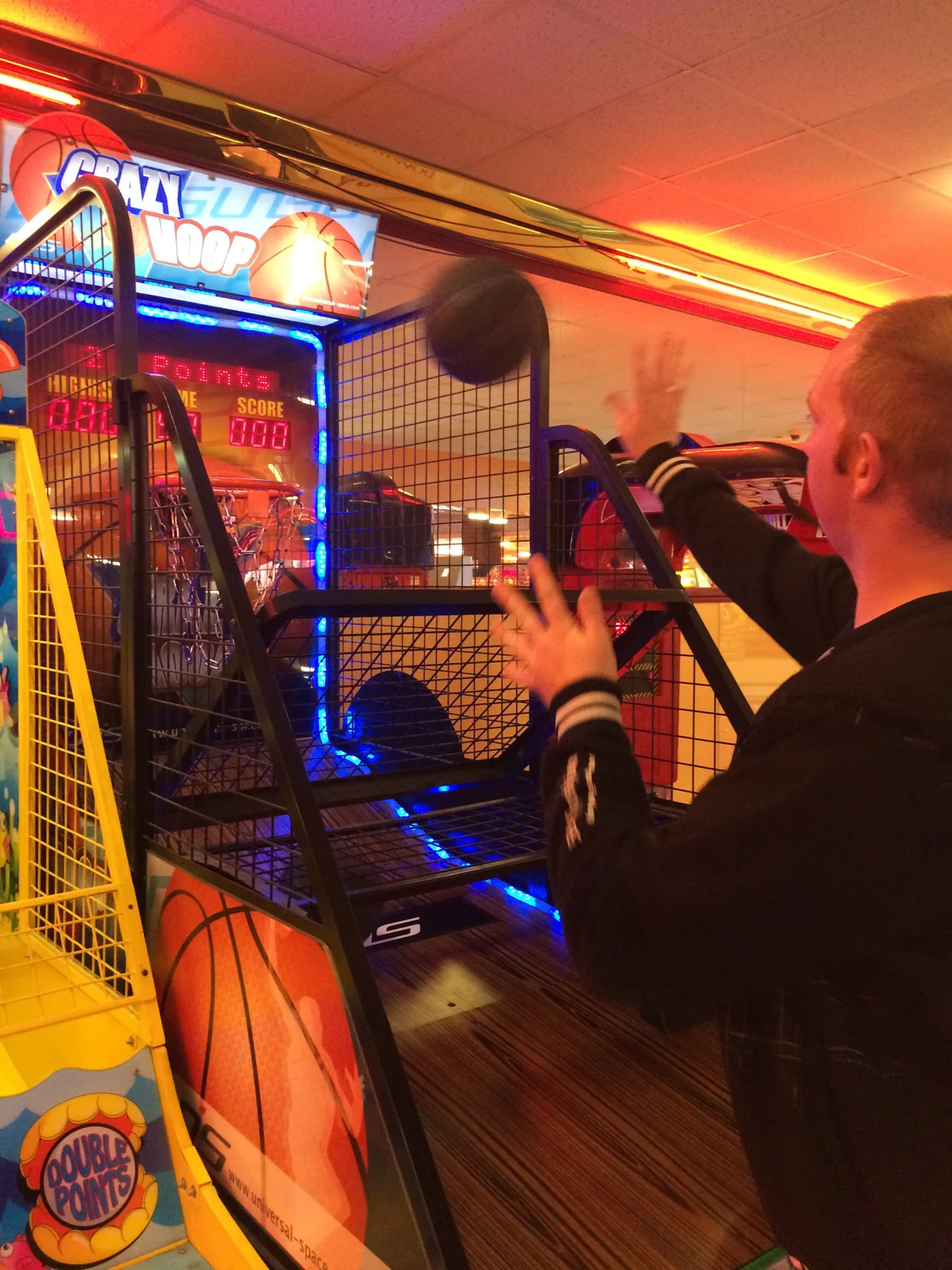 A man playing an arcade basketball game