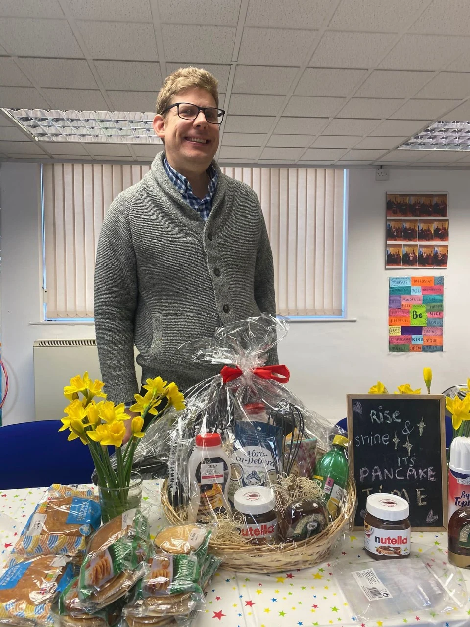 A man standing beside a display of gifts and flowers