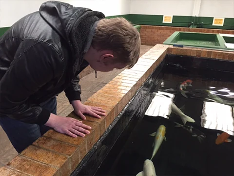 A man leaning over an indoor water display